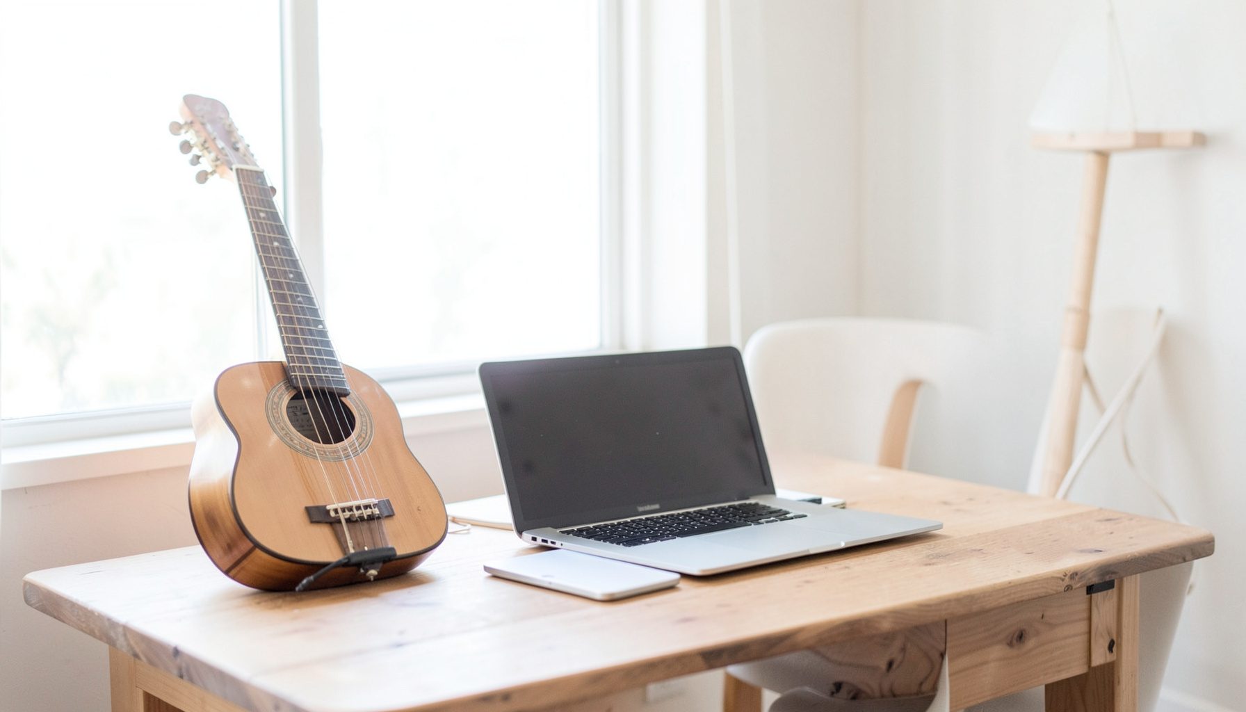 Bright, airy studio scene with acoustic instruments and a laptop on a wooden desk, soft natural light from a large window